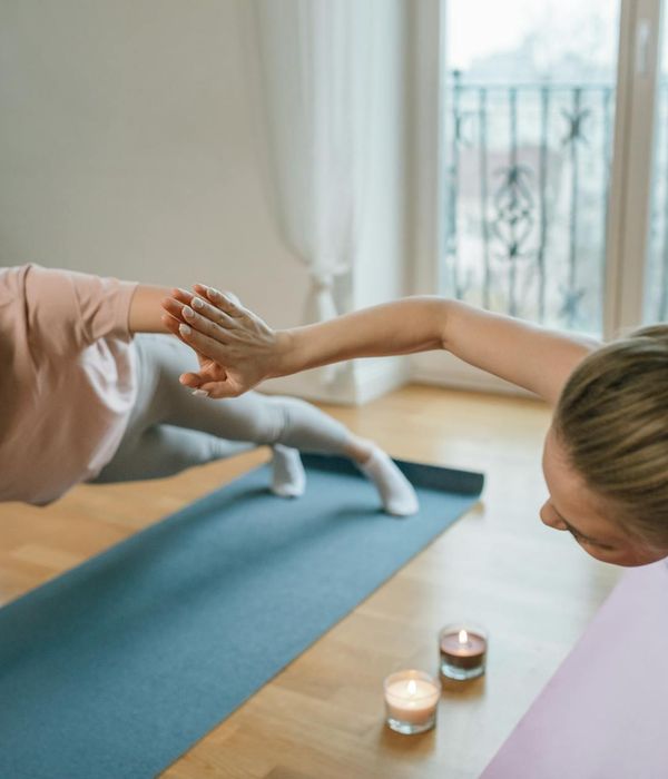 Woman performing a gentle yoga stretch in a bright, peaceful room.